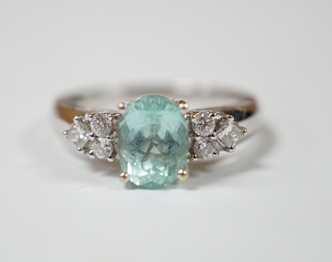 A modern 18ct gold and oval cut paraiba tourmaline set dress ring with six stone diamond set shoulders, size O, gross weight 4.9 grams.